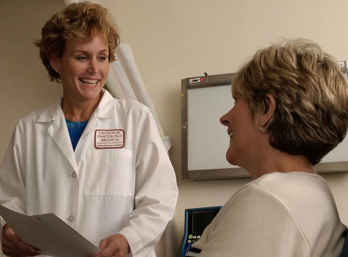 Family physician talking with a smiling patient in a clinic