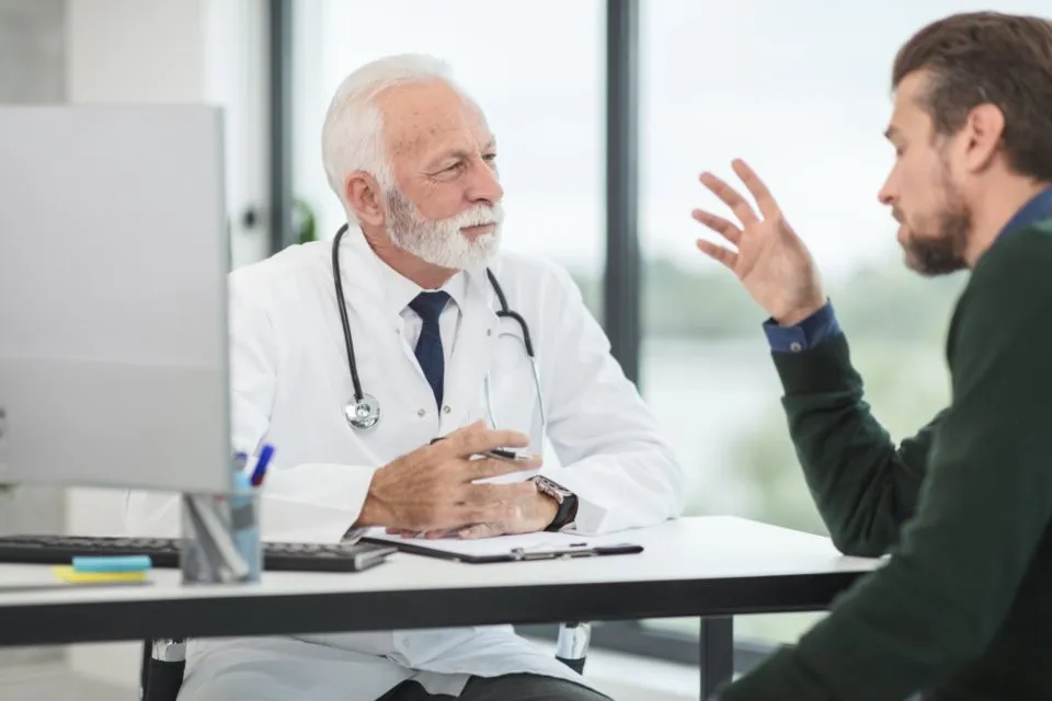 Physician consulting with a patient at a desk in a private office